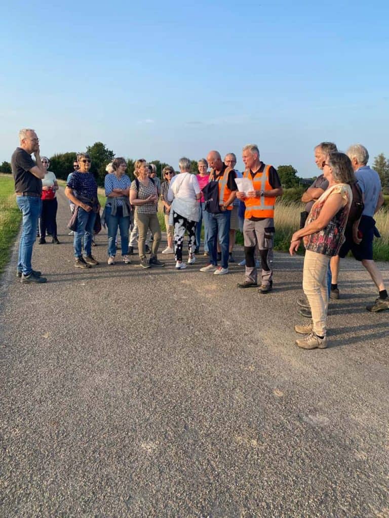 Veilig groepswandeling op 't Gelders Eiland met gids en toeristen in de buitenlucht.