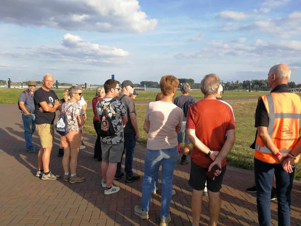 Groep toeristen op 't Gelders Eiland tijdens een excursie in de buitenlucht.