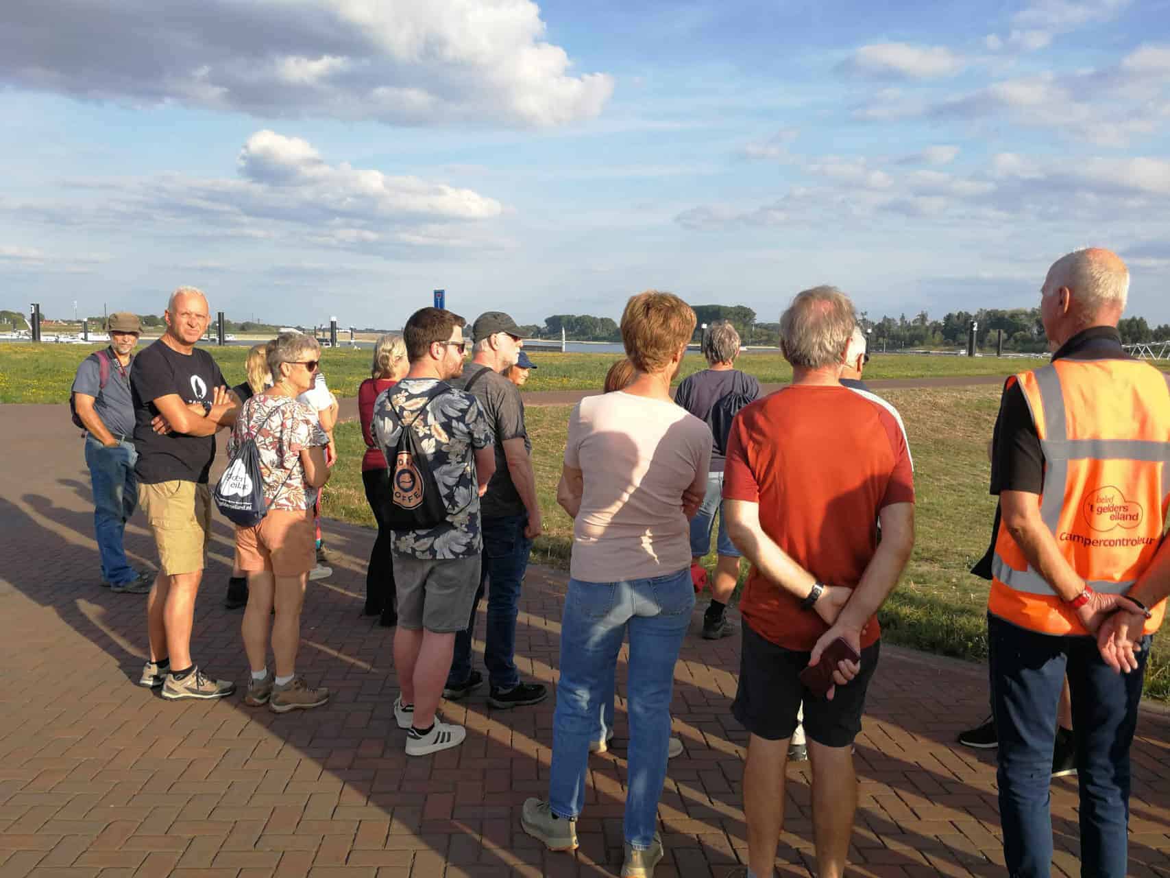 Groep toeristen op 't Gelders Eiland tijdens een excursie in de buitenlucht.