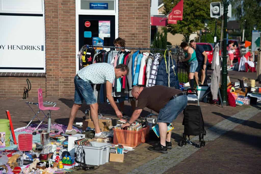 Een vlooienmarkt op 't Gelders Eiland met diverse tweedehands spullen en enthousiaste bezoekers.
