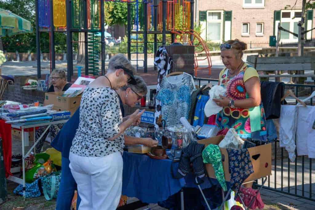 Sfeervolle markt op 't Gelders Eiland met diverse kraampjes en bezoekers.