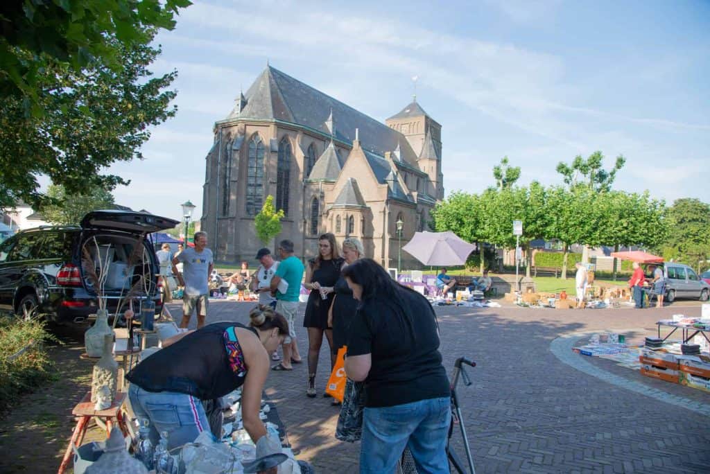 Kerk op 't Gelders Eiland met markt en bezoekers in de voorgrond.