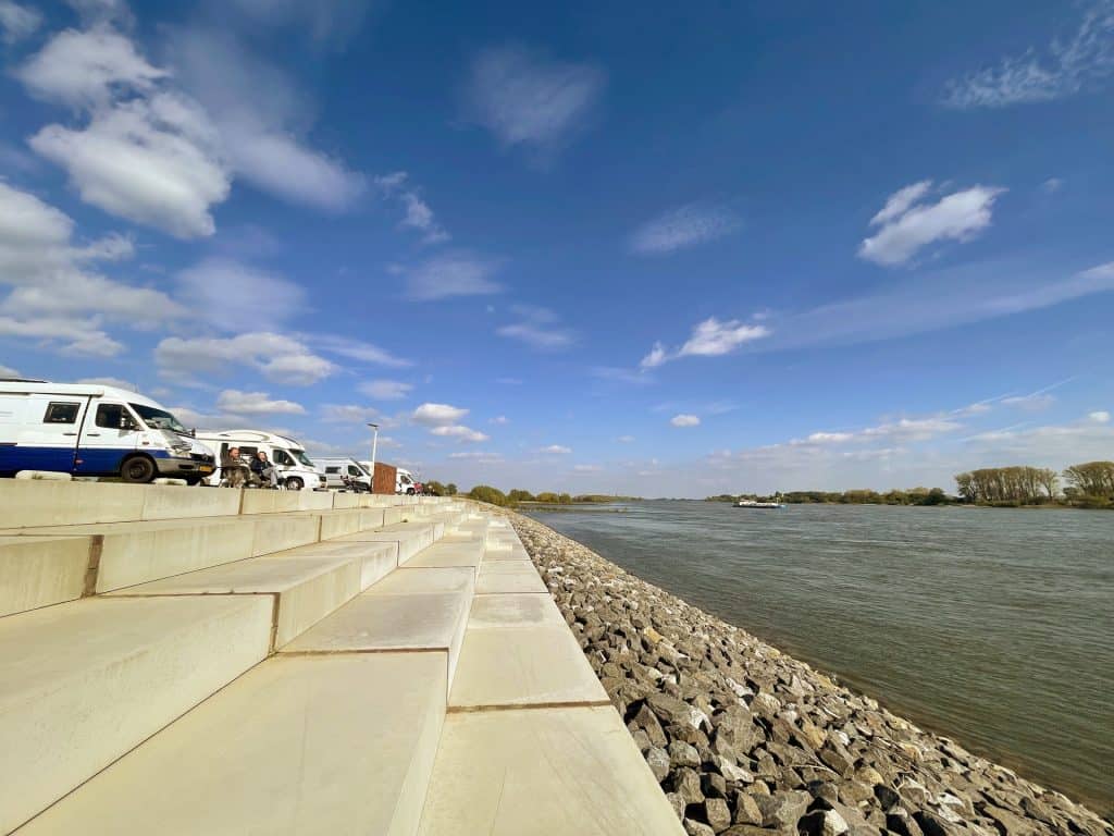 Zandwallen en rivier op 't Gelders Eiland onder een heldere blauwe hemel.