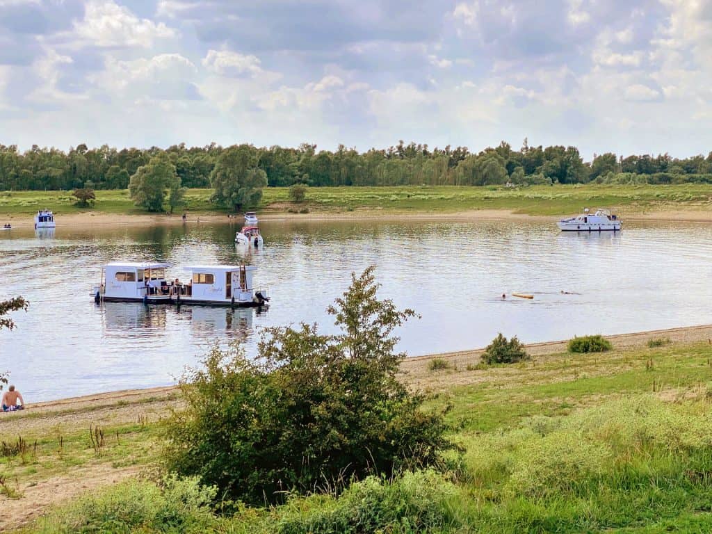 Boottocht op de rivier bij 't Gelders Eiland met boten en natuurlandschap.