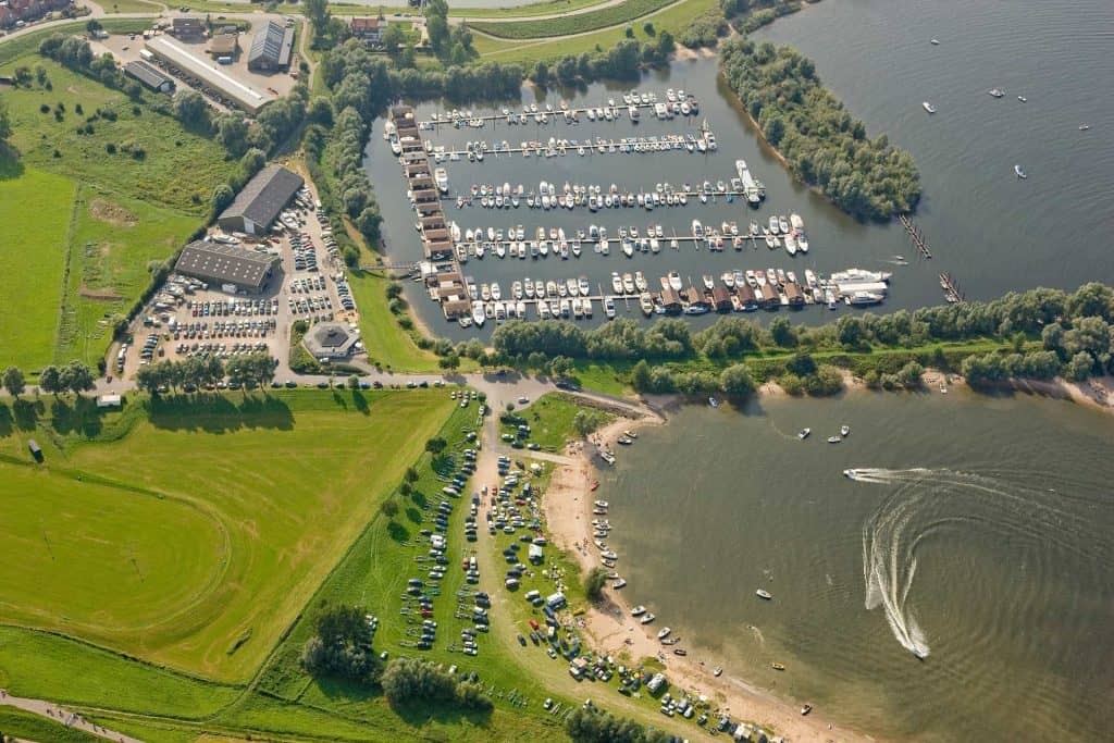 Zicht op jachthaven en recreatiegebied op 't Gelders Eiland, met boten, parkeerplaatsen en groene om.