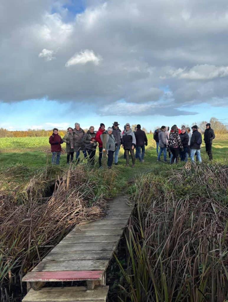 Zicht op een groep mensen op 't Gelders Eiland tijdens een excursie of wandeling in de natuur.