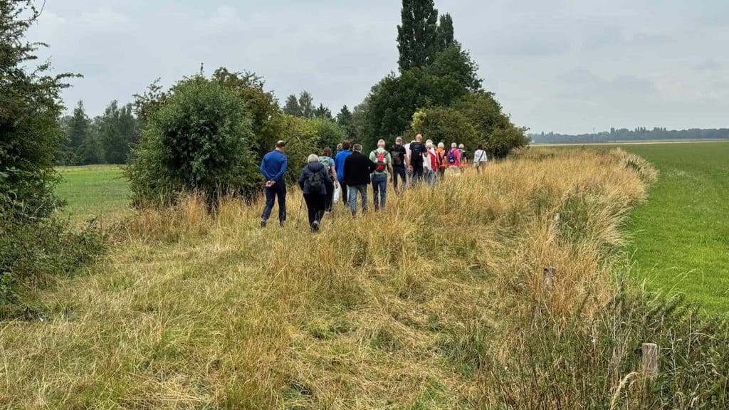 Wandelaars op 't Gelders Eiland genieten van een natuurwandeling in het landschap.