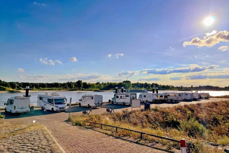 Camperplaatsen langs de rivier op 't Gelders Eiland met uitzicht op water en natuur.