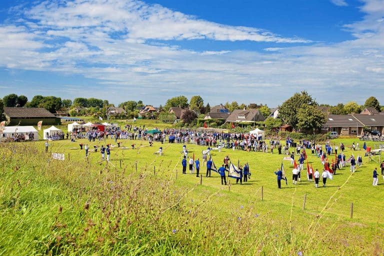 Gezellig dorpsfeest op 't Gelders Eiland met inwoners en bezoekers die genieten van muziek en activi.
