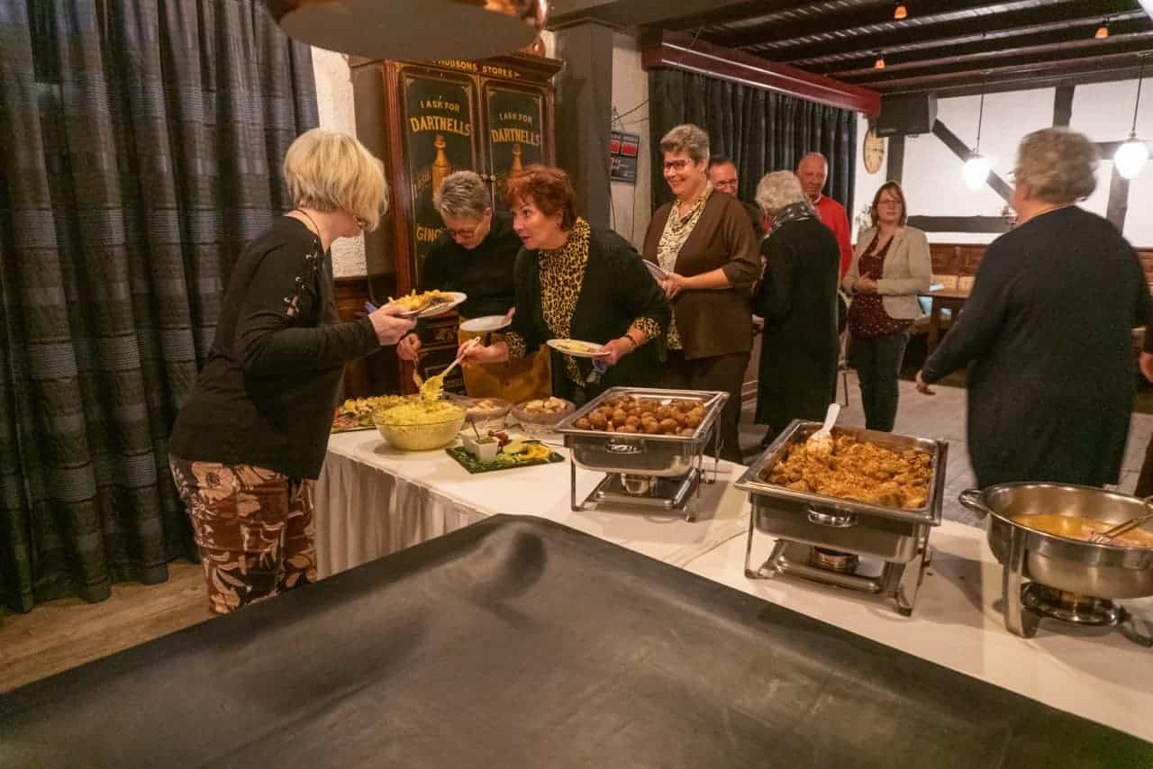 Vrijwilligers genieten van buffet tijdens gezellige avond op 't Gelders Eiland.