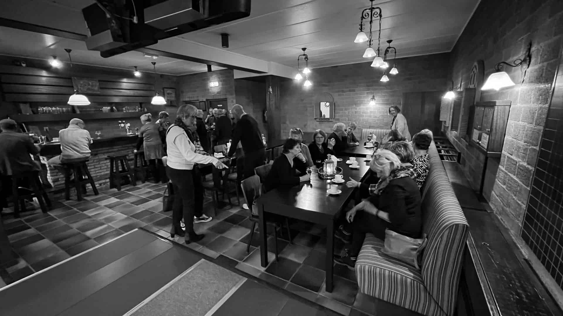 Vrijwilligers genieten van een gezellige kegelavond in een sfeervol café.