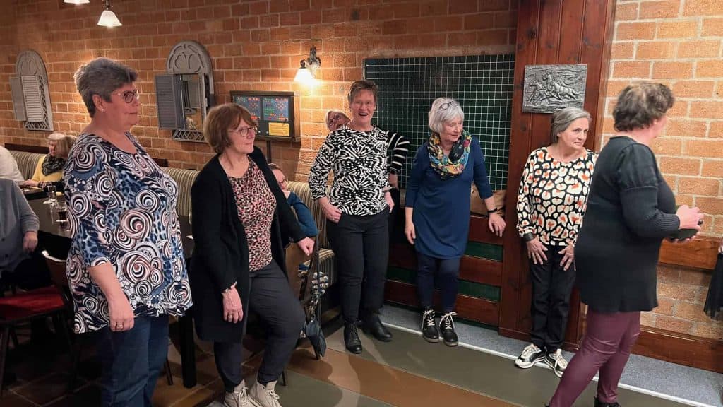 Vrolijke vrijwilligers spelen kegelen tijdens een gezellige avond.