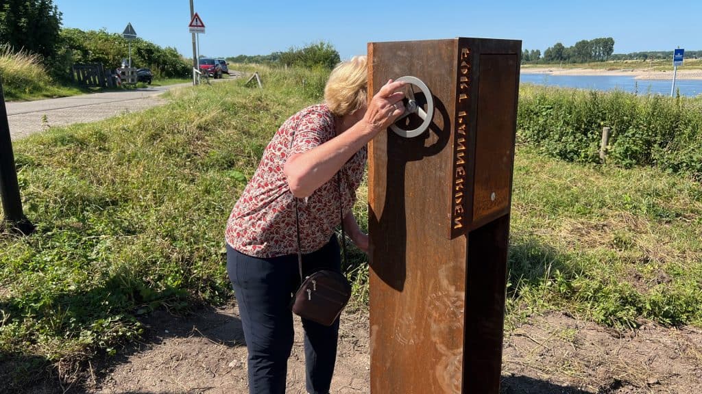 Vrouw gebruikt interactieve informatiezuil op 't Gelders Eiland.