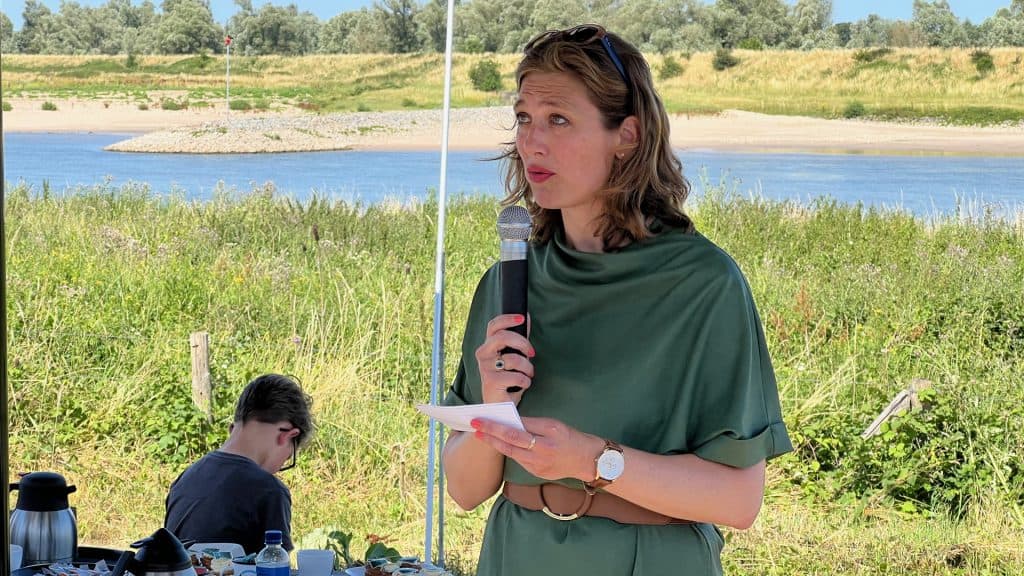 Vrouw spreekt tijdens buitenactiviteit op 't Gelders Eiland.