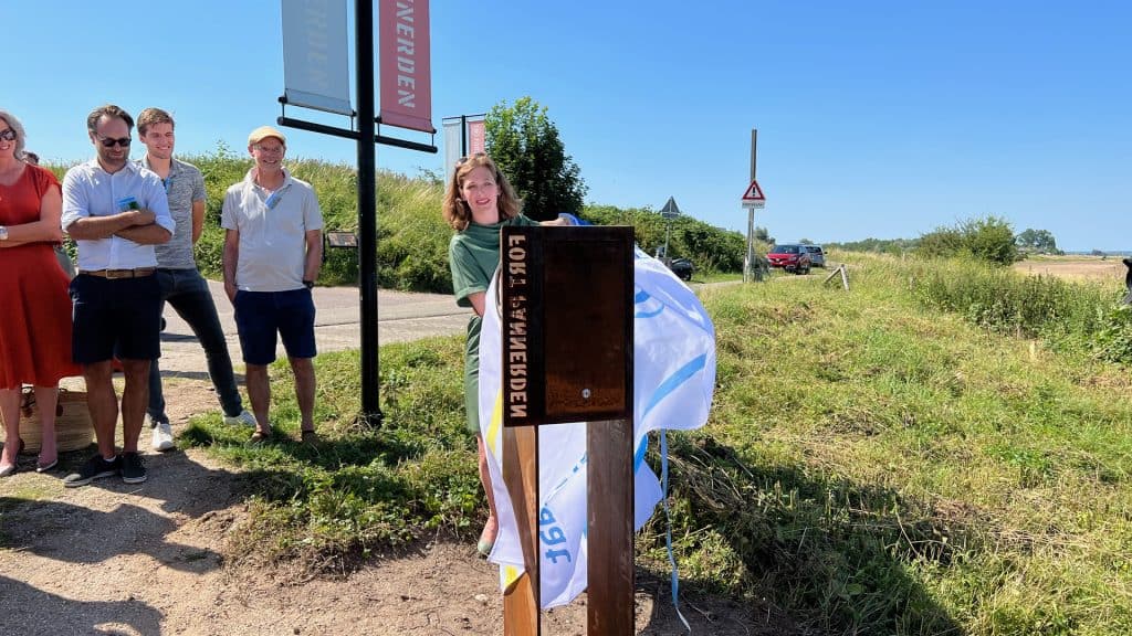 Groep mensen bij informatiebord op 't Gelders Eiland in zonnige omgeving.