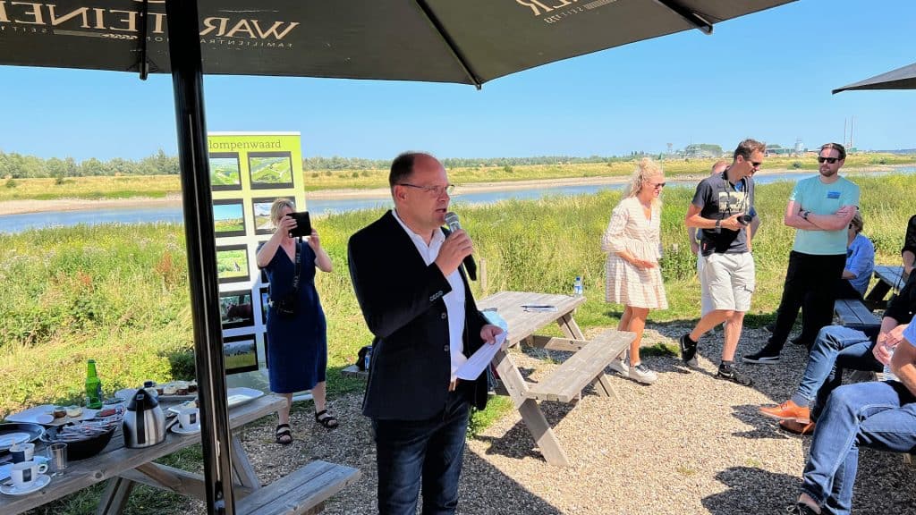 Man geeft presentatie onder parasol op 't Gelders Eiland.
