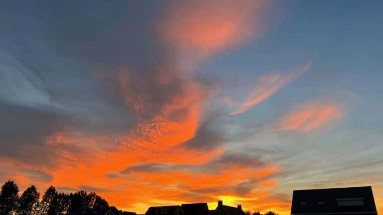 Prachtige zonsondergang met oranje en blauwe lucht boven 't Gelders Eiland.
