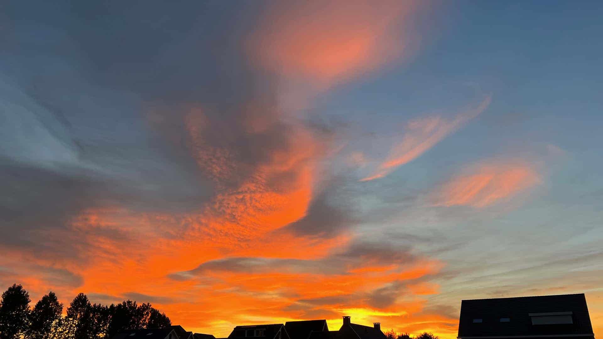 Prachtige zonsondergang met oranje en blauwe lucht boven 't Gelders Eiland.