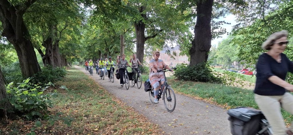 Vrijwilligers fietsen door een park op 't Gelders Eiland in Nederland.