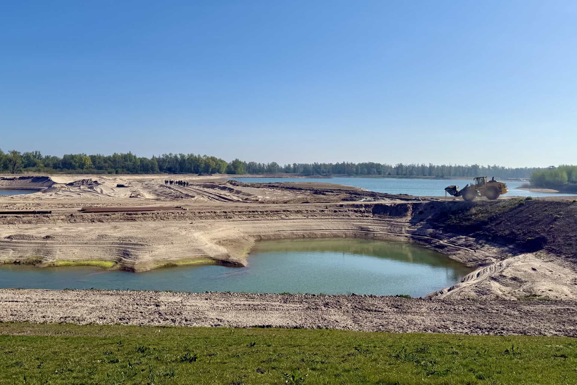 Bouw van een waterreservoir op 't Gelders Eiland met graafmachines en waterpartijen.