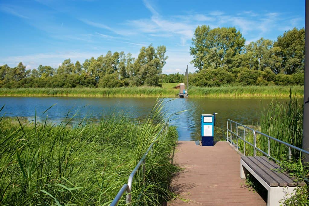 Draaipontje met uitzicht op water en groen landschap.