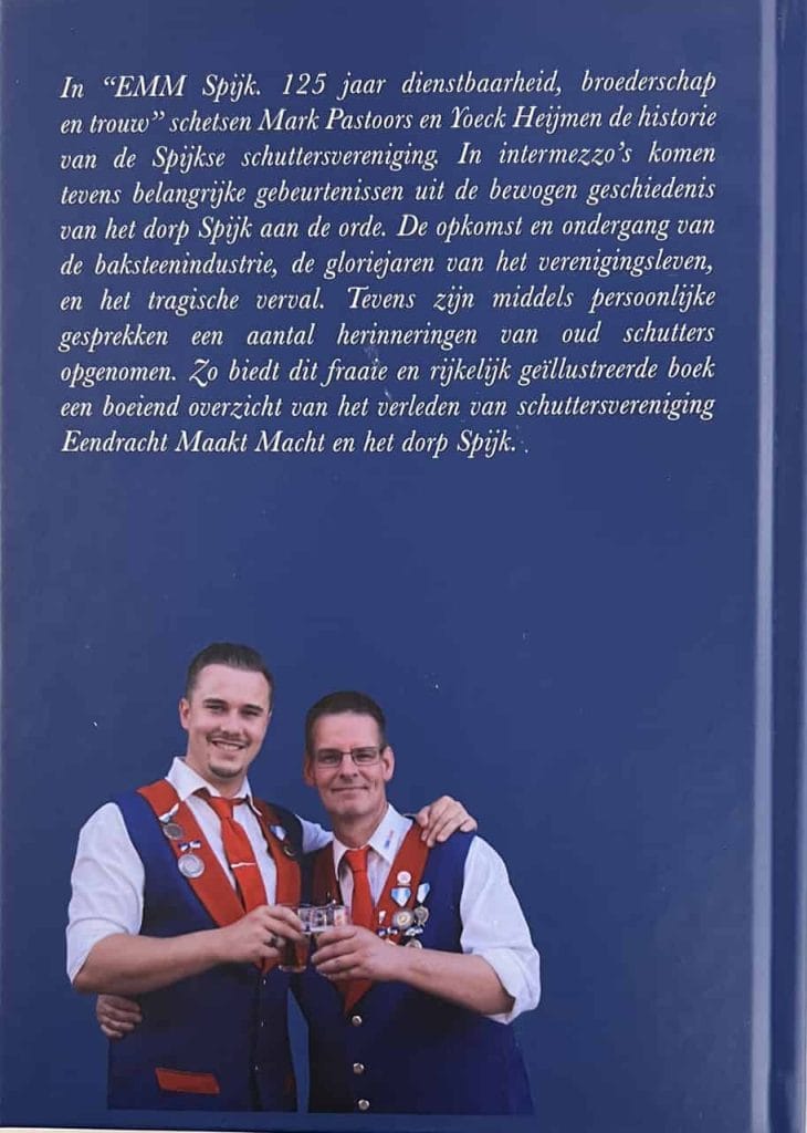 Twee mannen in traditionele kleding met medailles, feestelijk en trots.
