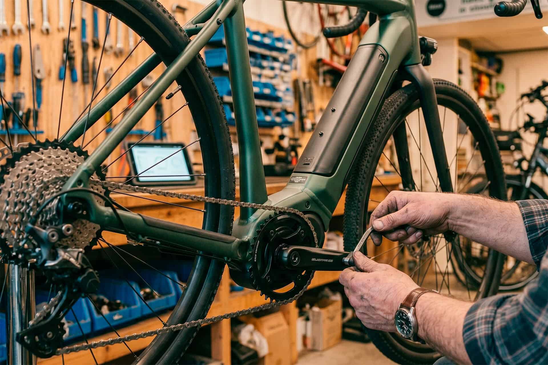 Persoon repareert elektrische fiets in fietsenmaker op 't Gelders Eiland.