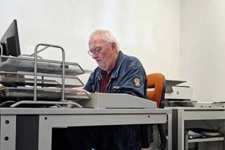 Oudere man werkt achter computer op kantoor.