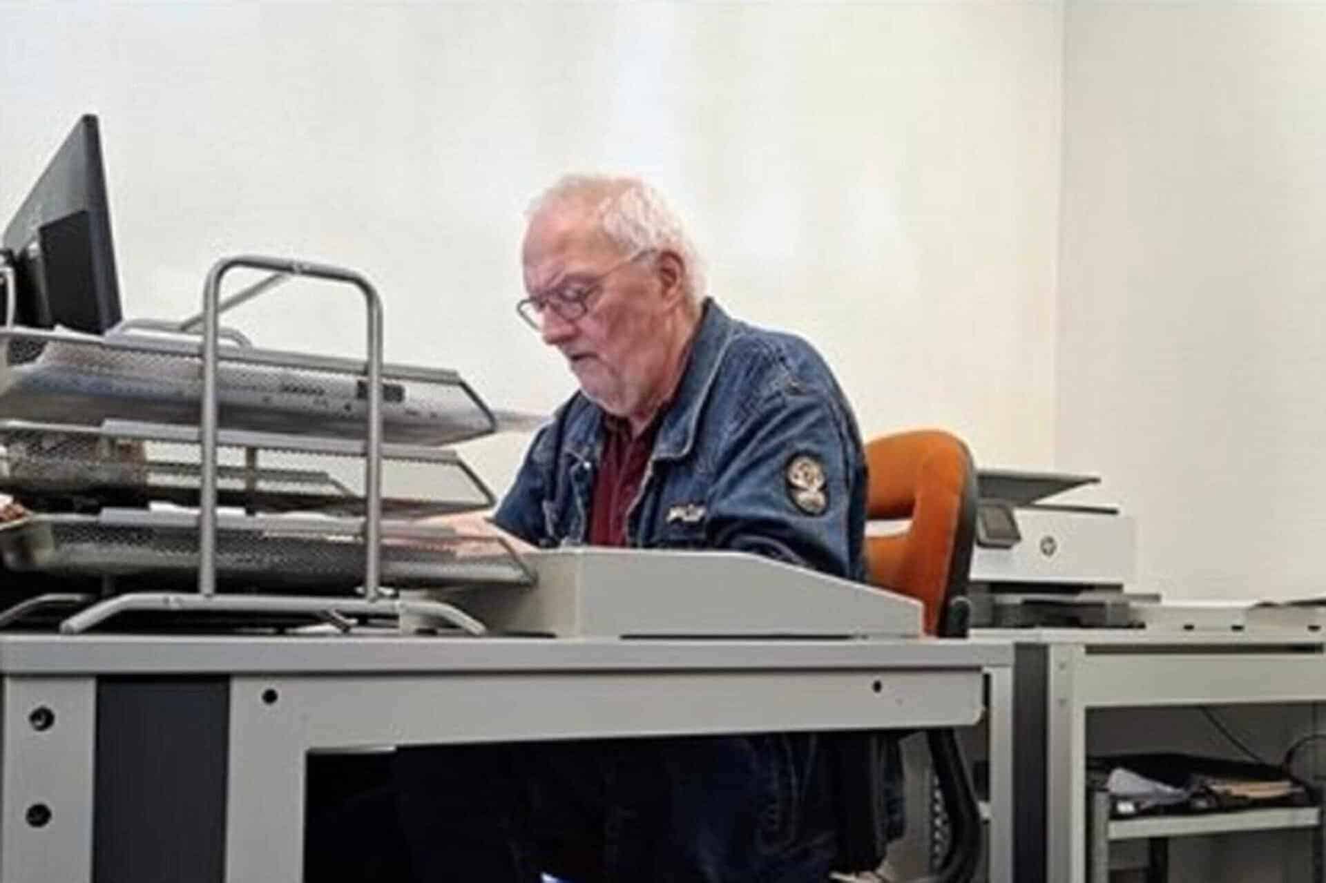 Oudere man werkt achter computer op kantoor.