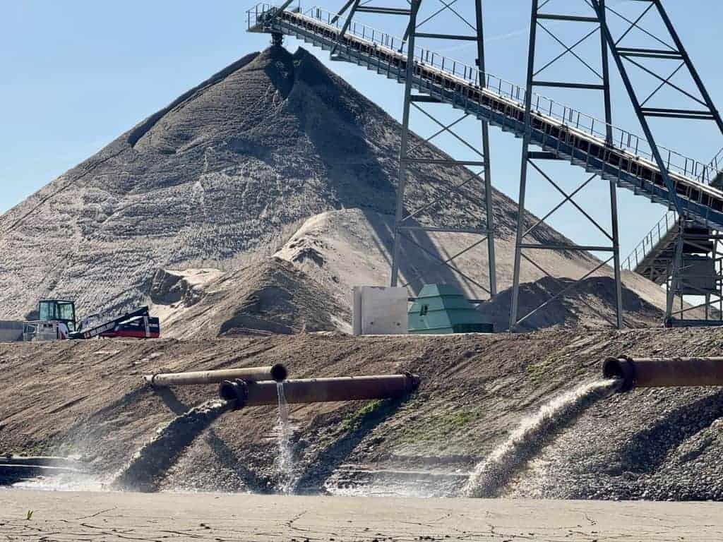 Zandwinning op 't Gelders Eiland met grote zandberg en industriële apparatuur.