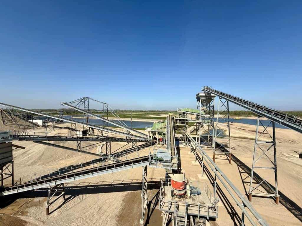 Zandwinning op 't Gelders Eiland met industriële installaties en conveyorbanden.