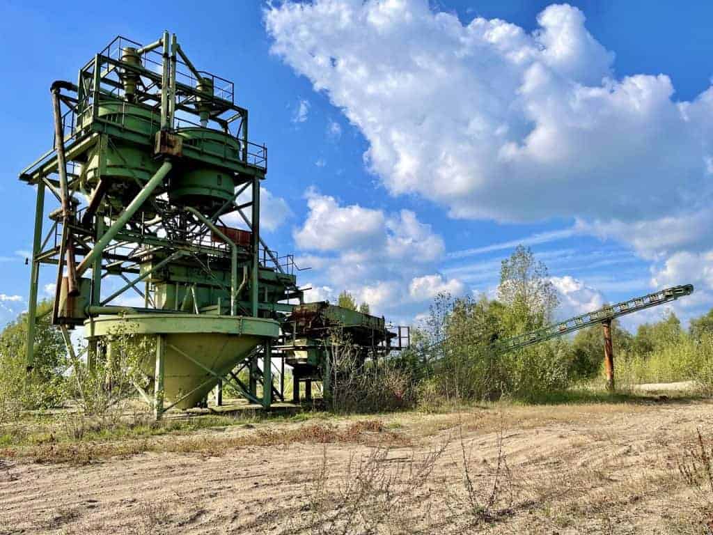Oude industriële fabriek op 't Gelders Eiland met groene structuur en blauwe lucht.