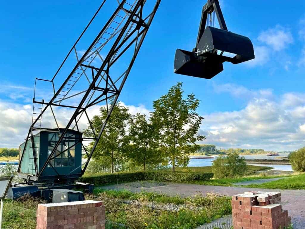 Kraan op 't Gelders Eiland met uitzicht op rivier en groene bomen.