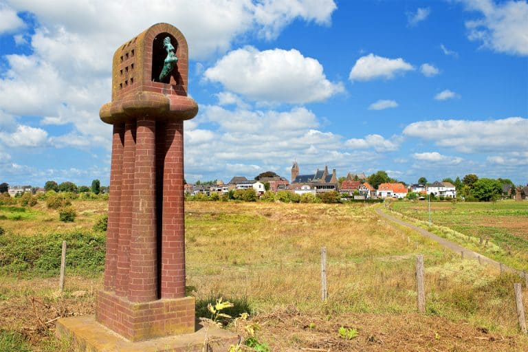 Monument op 't Gelders Eiland met uitzicht op dorp en landschap.