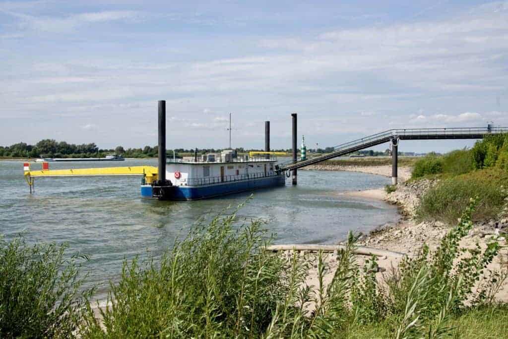 Gelders Eiland, rivier en scheepvaart, met een grote boot en sluis, in een landelijke omgeving.