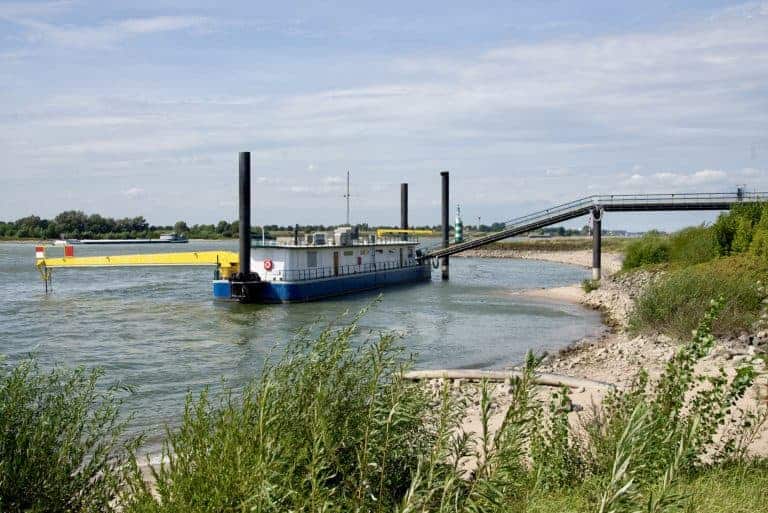 Gelders Eiland, rivier en scheepvaart, met een grote boot en sluis, in een landelijke omgeving.