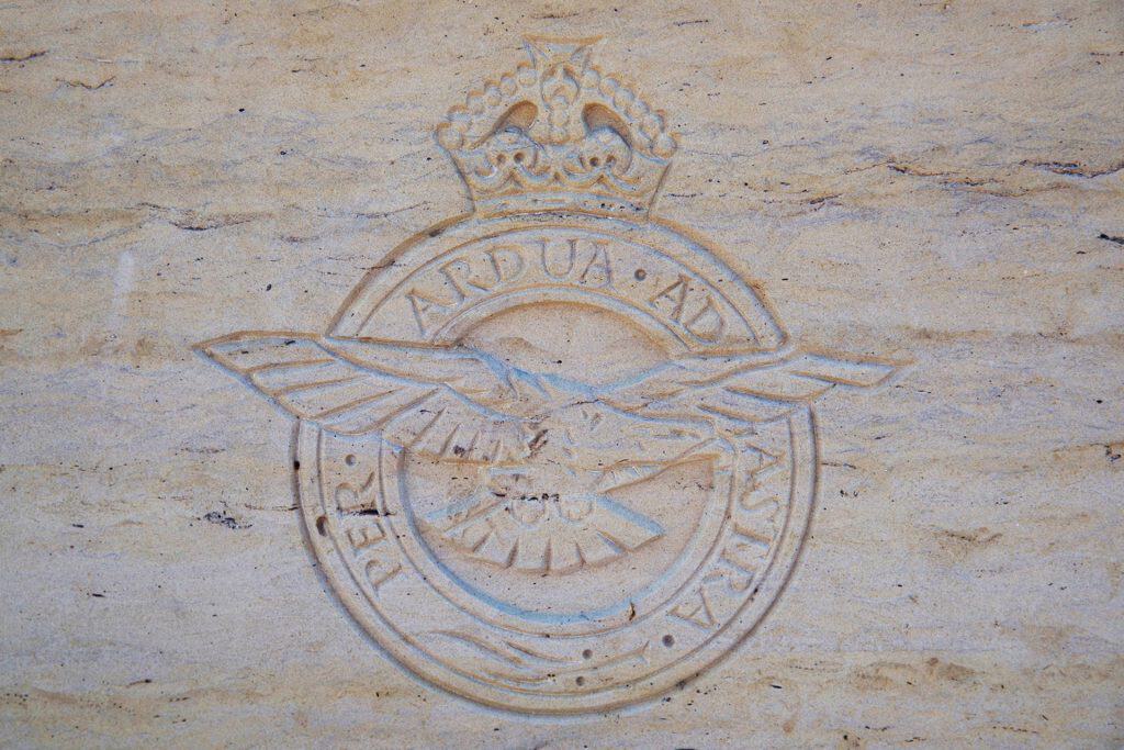 Luchtmacht embleem op zandkleurige muur, symboliseert militaire kracht en geschiedenis.