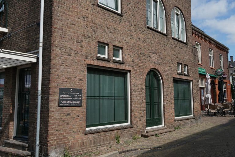 Oud gebouw met grote ramen en bakstenen gevel op 't Gelders Eiland.