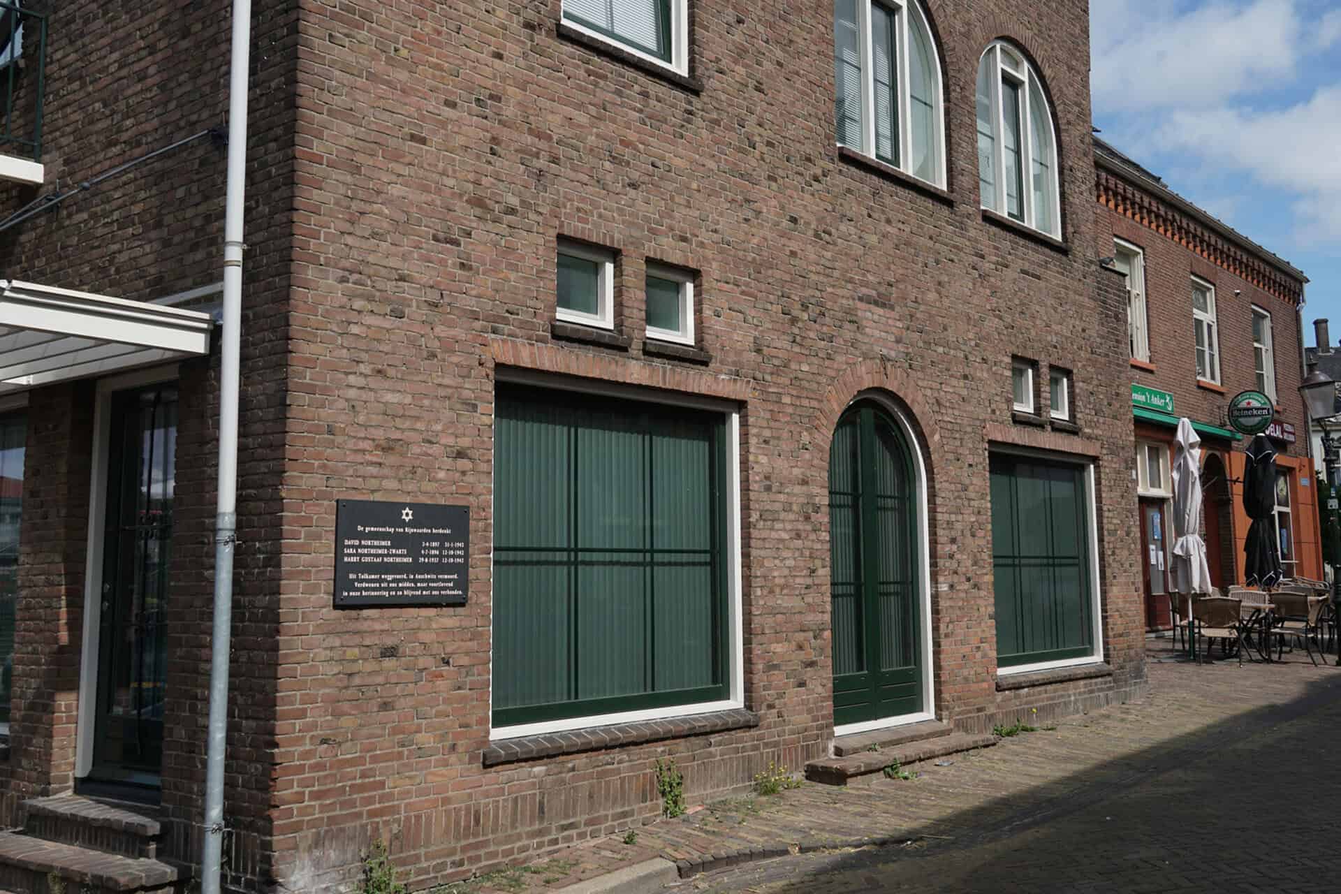 Oud gebouw met grote ramen en bakstenen gevel op 't Gelders Eiland.
