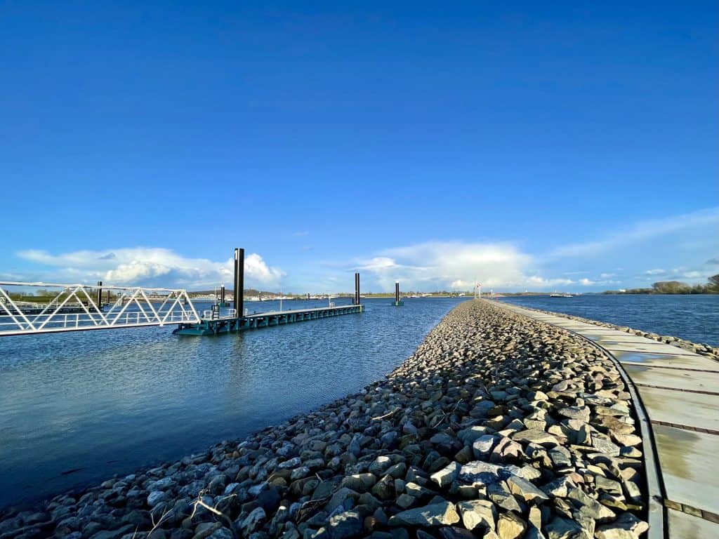 Uitzicht op de haven en waterweg op 't Gelders Eiland onder een heldere blauwe hemel.