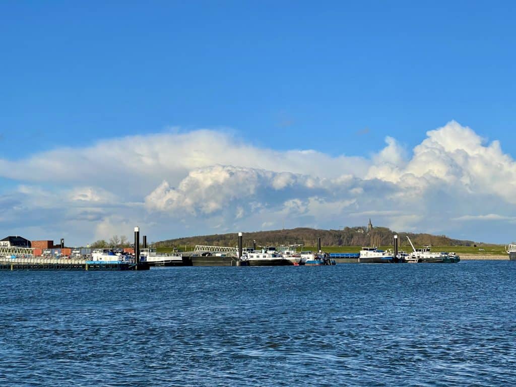 Gelders Eiland haven met boten, water en landschap onder een blauwe lucht.