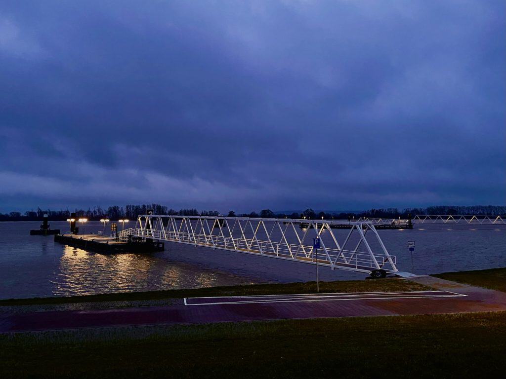Brug op 't Gelders Eiland bij schemering met donkere wolken en reflectie in het water.