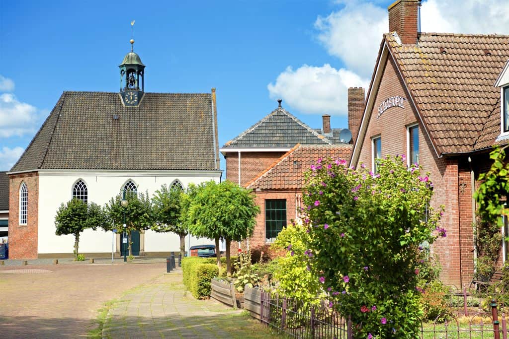 Kerk en dorpsplein op 't Gelders Eiland met historische gebouwen en groene omgeving.