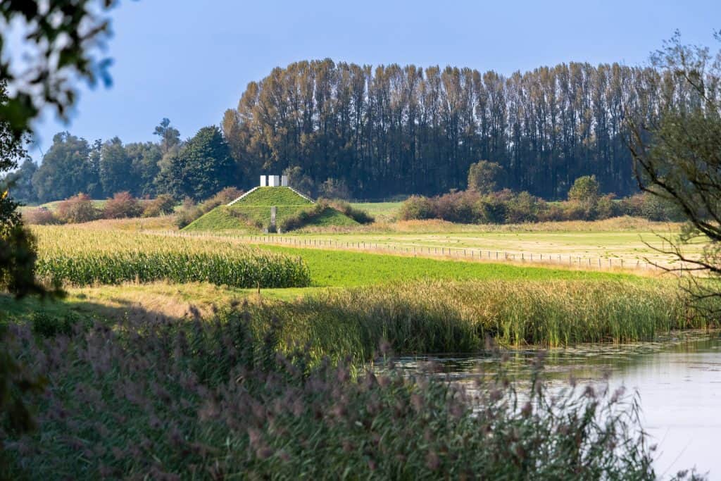 Uitzicht op groene velden en een waterkant op 't Gelders Eiland.