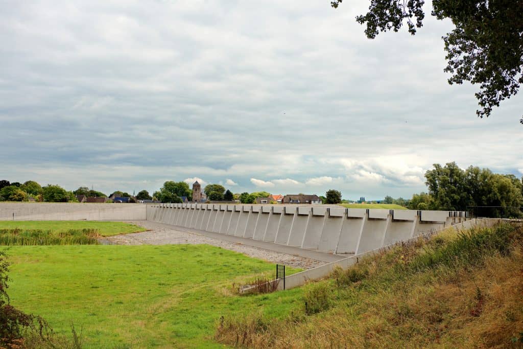 Waterkering op 't Gelders Eiland met groene velden en bomen.