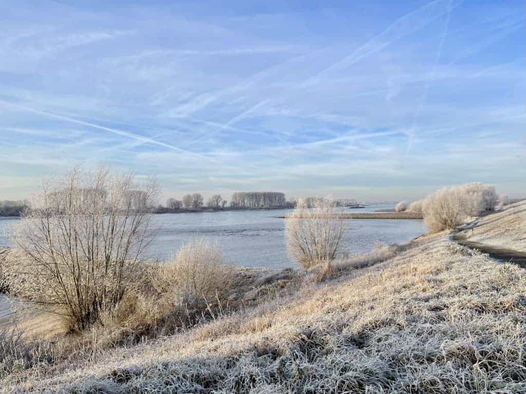 Uitzicht op 't Gelders Eiland met bevroren landschap en heldere hemel.