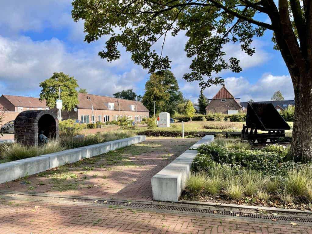 Kunstzinnig park op 't Gelders Eiland met zitplaatsen, bomen en groene omgeving, ideaal voor ontspan.