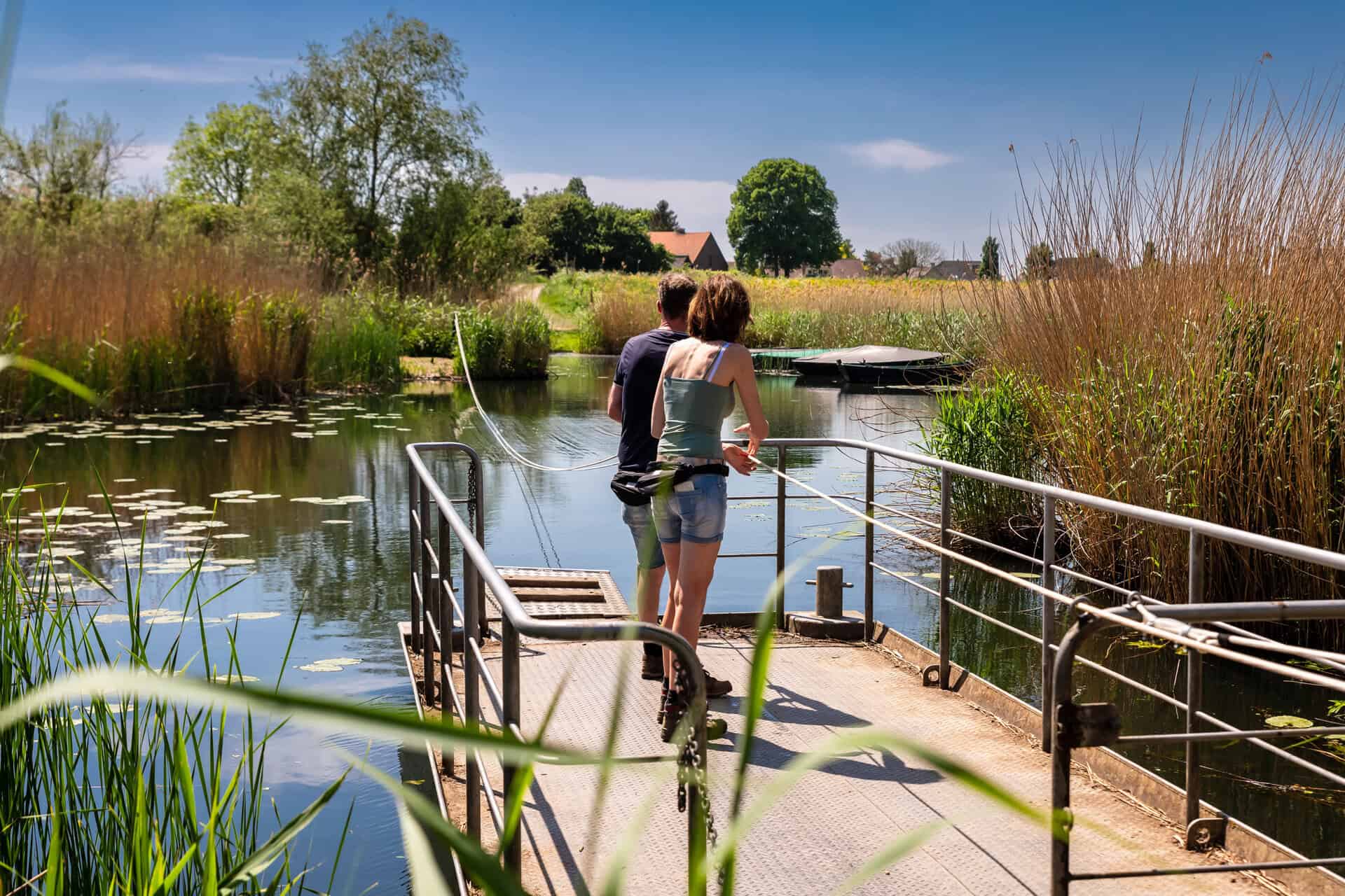 Twee mensen genieten van de natuur bij 't Gelders Eiland, uitzicht op water en groen.
