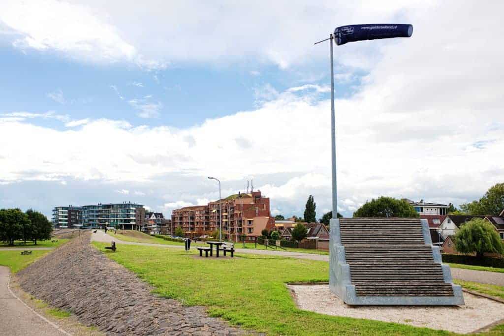 Monument op 't Gelders Eiland met uitzicht op recreatiegebied en moderne gebouwen.