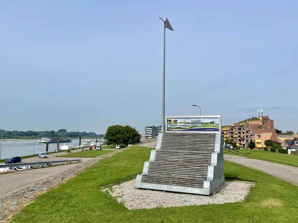 Uitzicht op 't Gelders Eiland met monument en rivier, zonnige dag.